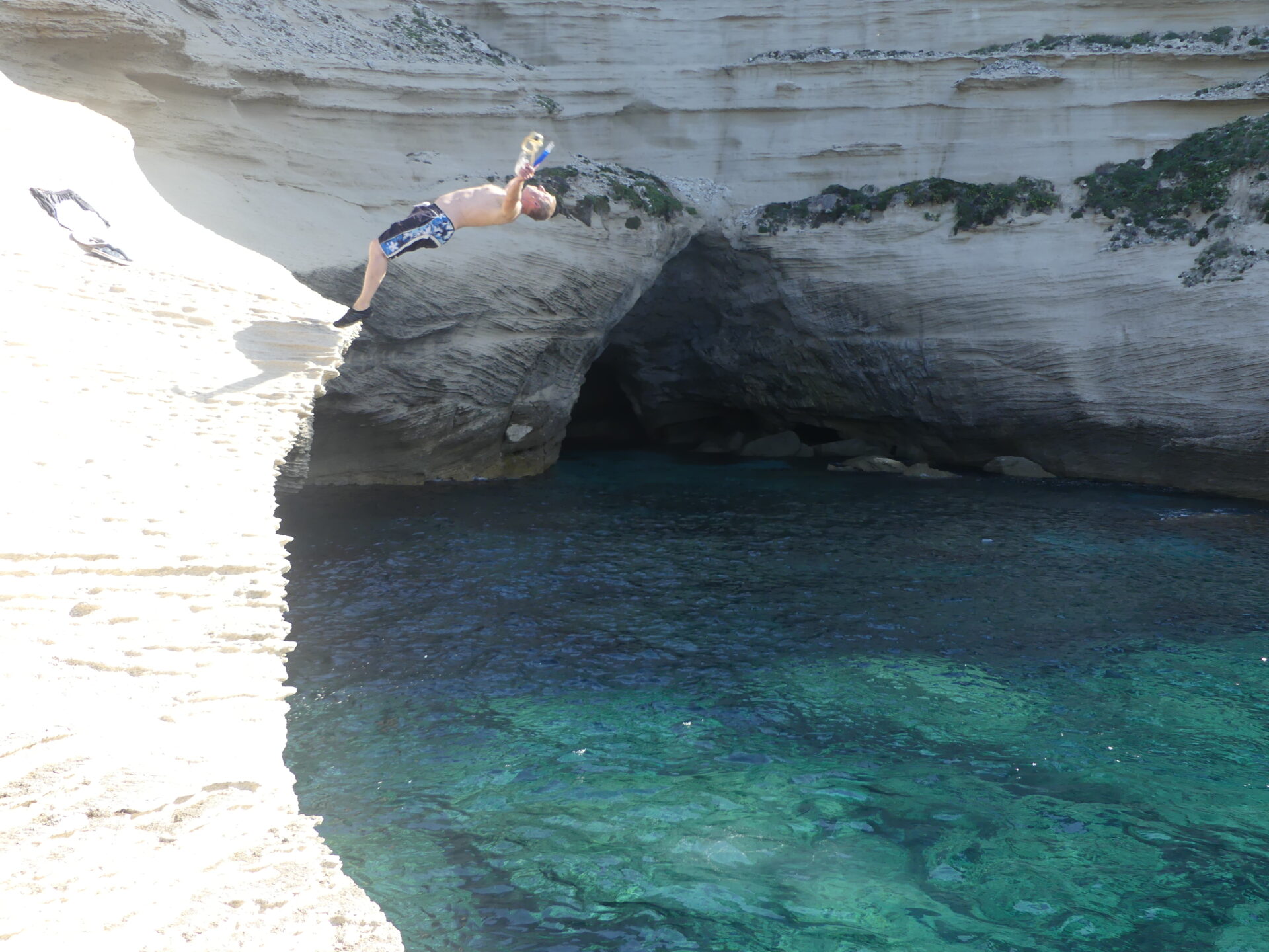 groupe paddling the cave of 'saint antoine' with 'pertusato' lighthouse on the background. groupe de kayakiste dans la grotte de saint antoine avec le phare de pertusato en arriere plan